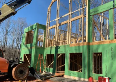 New home construction with tall exposed wood framing, green ZIP System sheathing